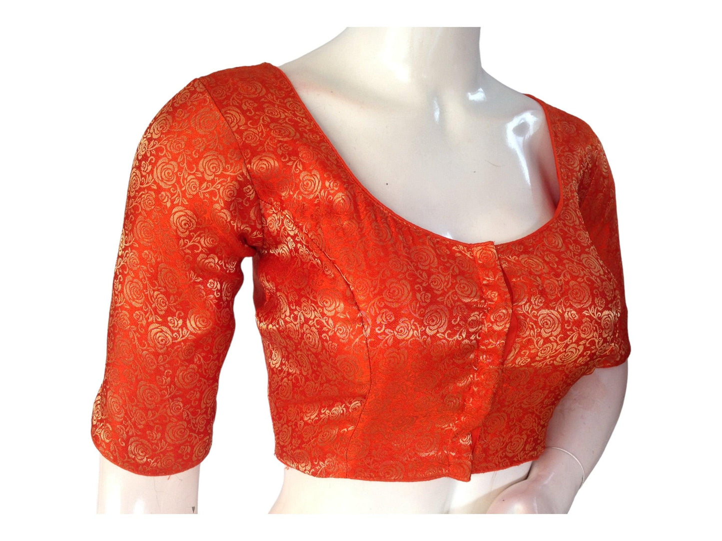 Elevate your ethnic ensemble with our Orange Brocade Readymade Saree Blouse, curated for plus-size wearers. Adorned with intricate detailing, this blouse adds a touch of sophistication to your look, perfect for enhancing your style with elegance and grace.