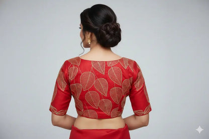 Red blouse with leaf patterns worn by a person on a gray background